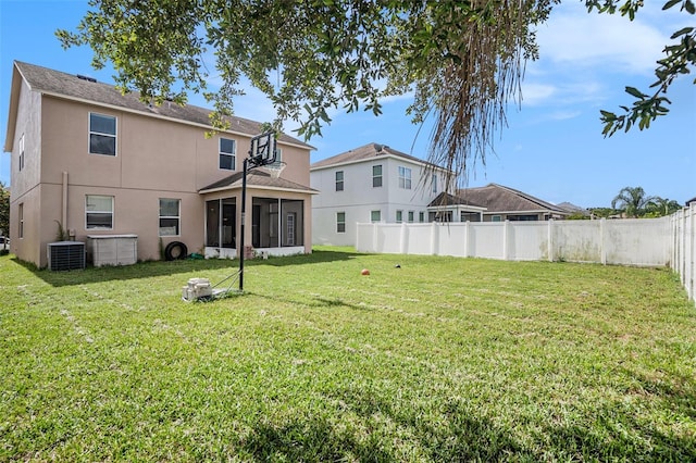 7641 Armonk Ln, Wesley Chapel, FL 33545 - back of house with stucco siding, a sunroom, and a fenced backyard
