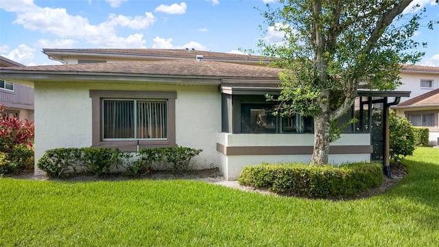 1851 Bough Ave Unit A, Clearwater, FL 33760 - rear view of house with a lawn, stucco siding, a shingled roof, and a sunroom