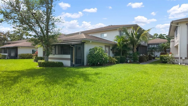 1851 Bough Ave Unit A, Clearwater, FL 33760 - rear view of house featuring stucco siding, a yard, and a sunroom