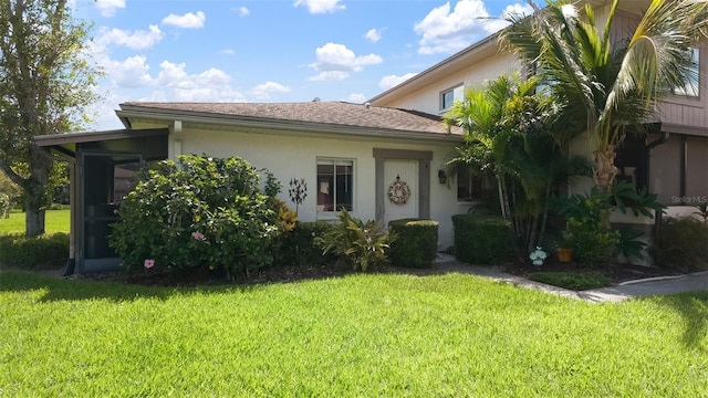 1851 Bough Ave Unit A, Clearwater, FL 33760 - view of front of property featuring stucco siding, a front yard, and a sunroom