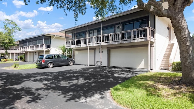 1851 Bough Ave Unit A, Clearwater, FL 33760 - view of front of property featuring stucco siding, asphalt driveway, a garage, and stairway