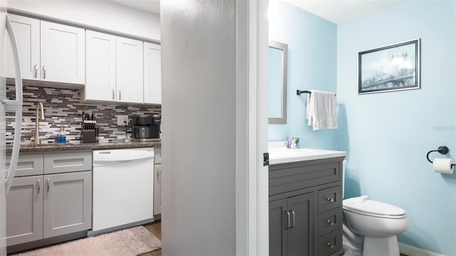 2941 Lichen Ln Unit B, Clearwater, FL 33760 - kitchen with white dishwasher, tasteful backsplash, gray cabinetry, wood finished floors, and white cabinetry