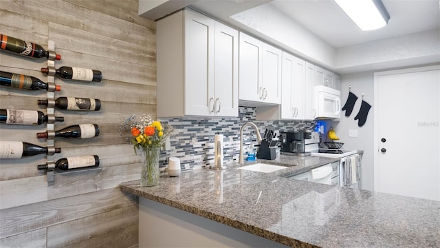 2941 Lichen Ln Unit B, Clearwater, FL 33760 - kitchen featuring white appliances, light stone countertops, tasteful backsplash, and white cabinetry