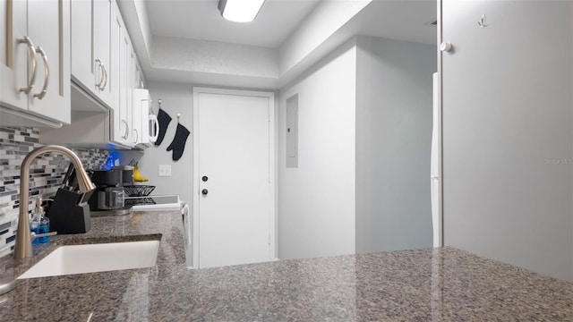 2941 Lichen Ln Unit B, Clearwater, FL 33760 - kitchen with electric panel, backsplash, white cabinetry, and dark stone countertops