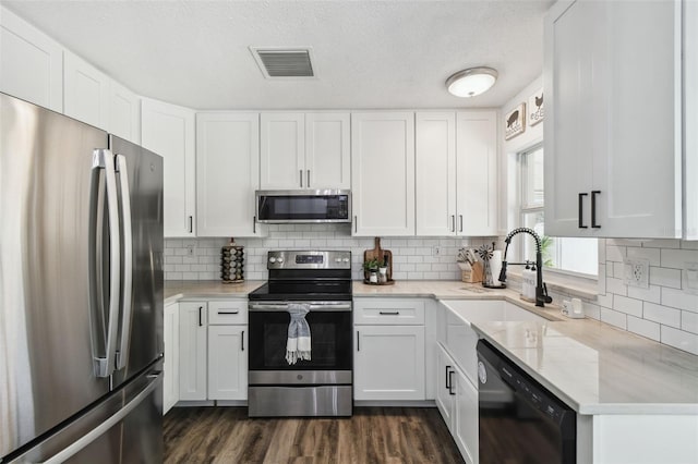 3628 Dellefield St, New Port Richey, FL 34655 - kitchen featuring appliances with stainless steel finishes, a sink, white cabinets, backsplash, and light stone counters