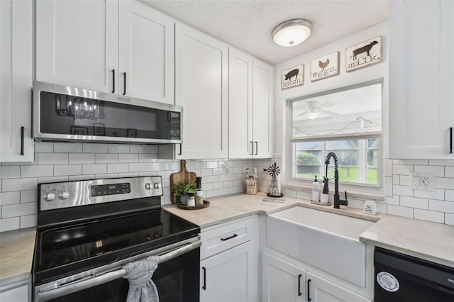 3628 Dellefield St, New Port Richey, FL 34655 - kitchen featuring appliances with stainless steel finishes, a sink, white cabinetry, decorative backsplash, and a textured ceiling