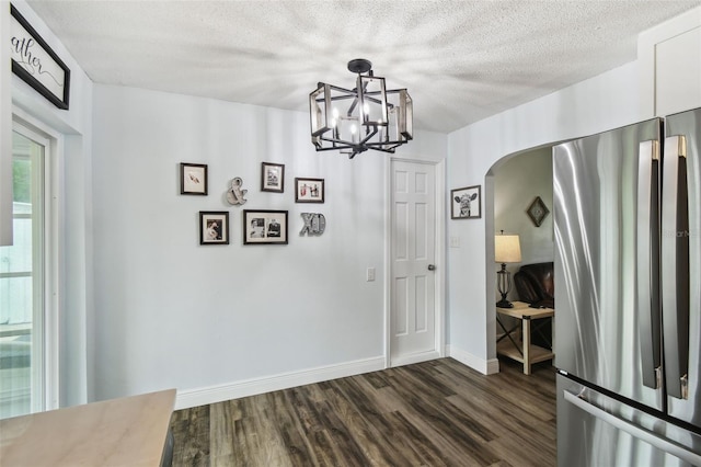 3628 Dellefield St, New Port Richey, FL 34655 - unfurnished dining area featuring arched walkways, dark wood finished floors, baseboards, a textured ceiling, and a chandelier