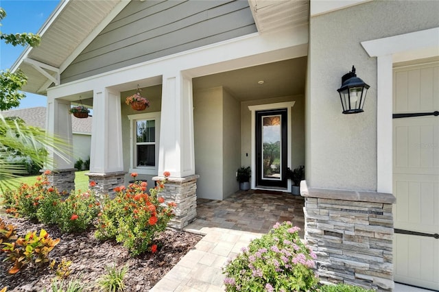7116 Estero Ct, Apollo Beach, FL 33572 - property entrance featuring a porch, stone siding, and stucco siding