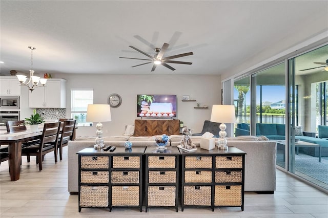 7116 Estero Ct, Apollo Beach, FL 33572 - living room featuring a ceiling fan, a chandelier, and light wood-type flooring