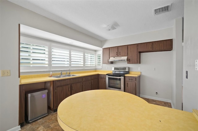 6841 Mitchell Cir, Tampa, FL 33634 - kitchen with stainless steel range with electric stovetop, under cabinet range hood, light countertops, and refrigerator