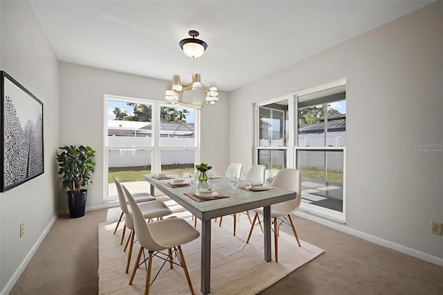 6841 Mitchell Cir, Tampa, FL 33634 - dining room featuring a chandelier, healthy amount of natural light, and light colored carpet