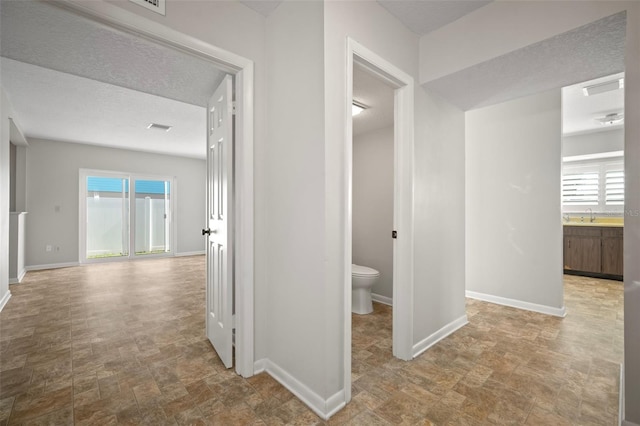 6841 Mitchell Cir, Tampa, FL 33634 - hall featuring plenty of natural light and a textured ceiling