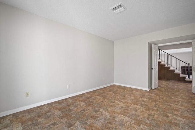 6841 Mitchell Cir, Tampa, FL 33634 - empty room with stone finish floors, stairway, and a textured ceiling