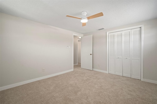 6841 Mitchell Cir, Tampa, FL 33634 - unfurnished bedroom with light carpet, a closet, a textured ceiling, and a ceiling fan