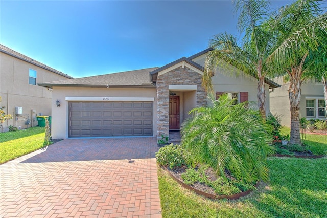 25200 Lambrusco Loop, Lutz, FL 33559 - view of front of property with decorative driveway, stucco siding, a garage, a front lawn, and stone siding