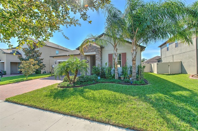 25200 Lambrusco Loop, Lutz, FL 33559 - view of front of property featuring decorative driveway, stone siding, a garage, stucco siding, and a gate