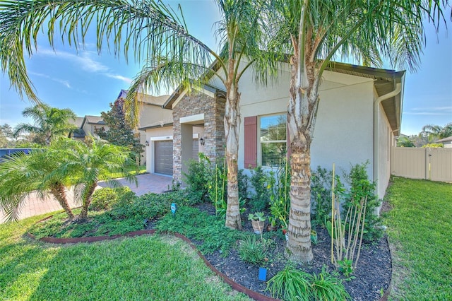 25200 Lambrusco Loop, Lutz, FL 33559 - view of front of house with stucco siding, a garage, driveway, and stone siding