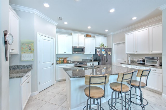 25200 Lambrusco Loop, Lutz, FL 33559 - kitchen featuring stainless steel appliances, light tile patterned floors, dark stone counters, a kitchen island with sink, and recessed lighting