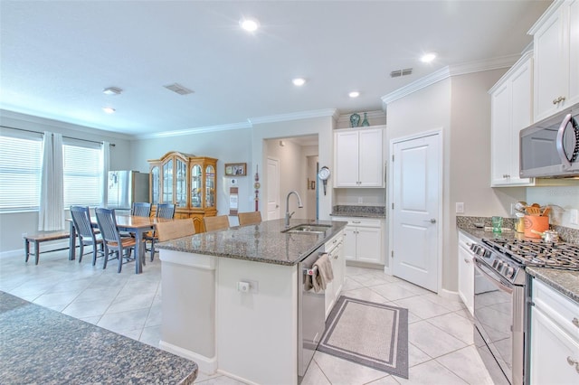 25200 Lambrusco Loop, Lutz, FL 33559 - kitchen with stainless steel appliances, light tile patterned floors, dark stone countertops, white cabinets, and crown molding