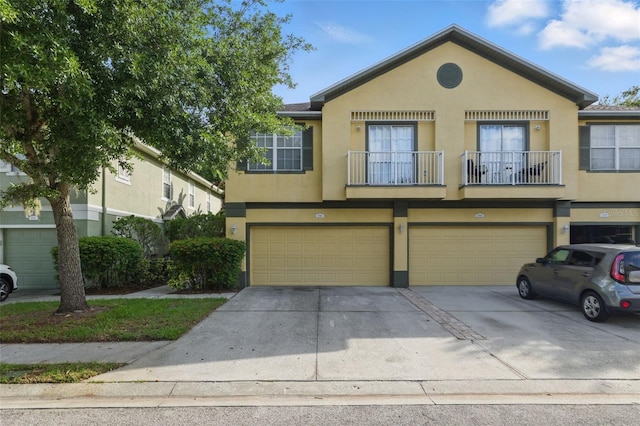 27563 Pleasure Ride Loop, Wesley Chapel, FL 33544 - multi unit property with stucco siding, concrete driveway, a balcony, and an attached garage