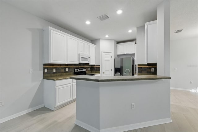 27563 Pleasure Ride Loop, Wesley Chapel, FL 33544 - kitchen featuring white microwave, stainless steel refrigerator with ice dispenser, electric range oven, tasteful backsplash, and a peninsula