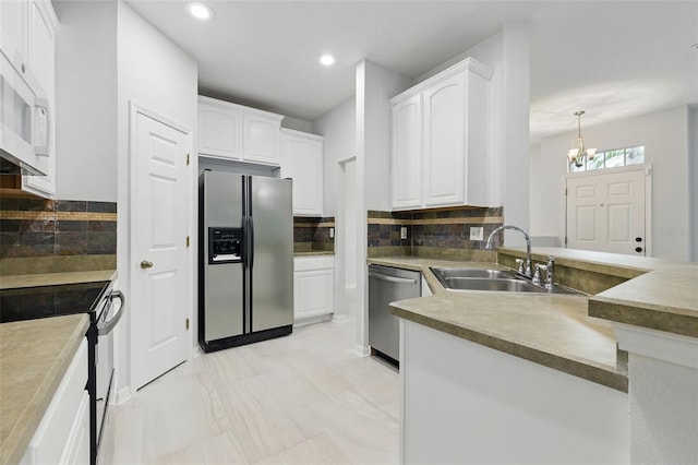 27563 Pleasure Ride Loop, Wesley Chapel, FL 33544 - kitchen with stainless steel appliances, tasteful backsplash, a chandelier, white cabinetry, and recessed lighting