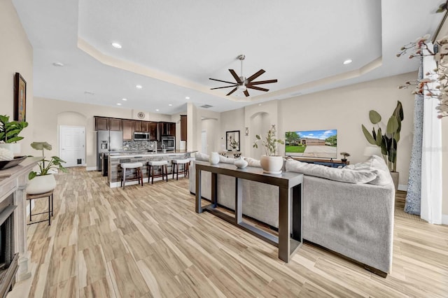 32624 Summerglade Dr, Wesley Chapel, FL 33545 - living area featuring a raised ceiling, arched walkways, ceiling fan, recessed lighting, and light wood-type flooring
