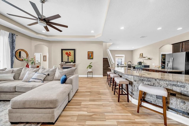 32624 Summerglade Dr, Wesley Chapel, FL 33545 - living area with arched walkways, a ceiling fan, recessed lighting, light wood-type flooring, and a textured ceiling