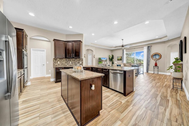 32624 Summerglade Dr, Wesley Chapel, FL 33545 - kitchen with arched walkways, appliances with stainless steel finishes, ceiling fan, a peninsula, and recessed lighting