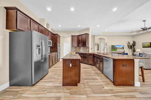 32624 Summerglade Dr, Wesley Chapel, FL 33545 - kitchen with stainless steel appliances, arched walkways, a peninsula, open floor plan, and a kitchen island