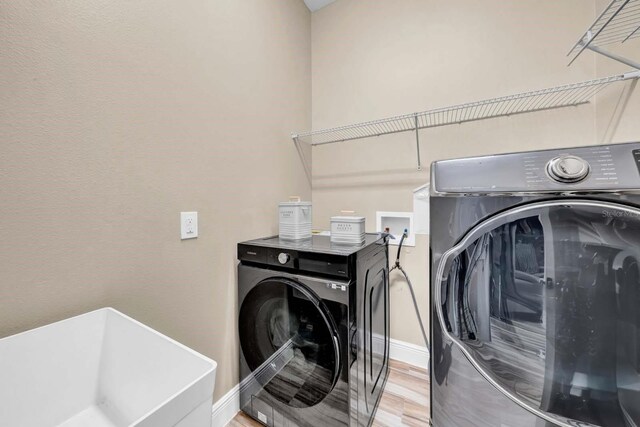 32624 Summerglade Dr, Wesley Chapel, FL 33545 - laundry area featuring washer and dryer and light wood finished floors