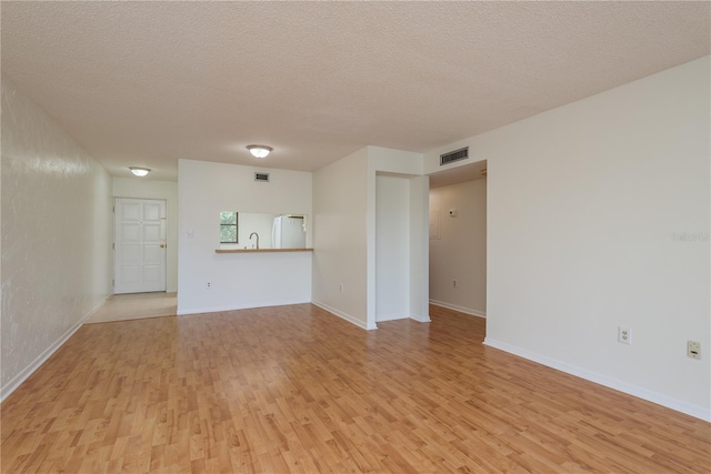2650 Countryside Blvd Unit C204, Clearwater, FL 33761 - unfurnished living room featuring light wood-style flooring and a textured ceiling