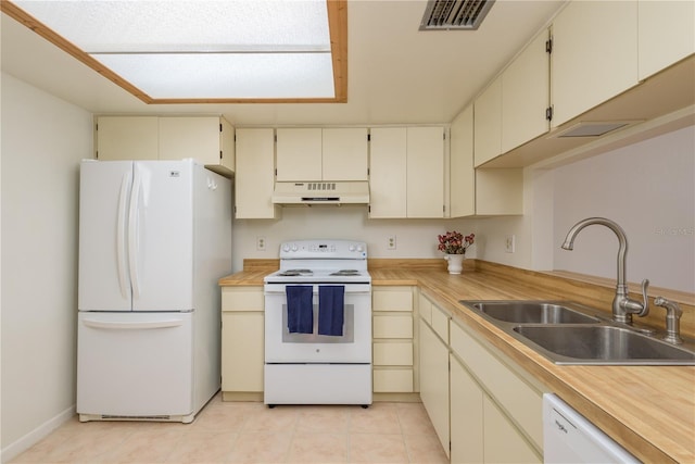 2650 Countryside Blvd Unit C204, Clearwater, FL 33761 - kitchen featuring white appliances, under cabinet range hood, light countertops, cream cabinets, and light tile patterned floors
