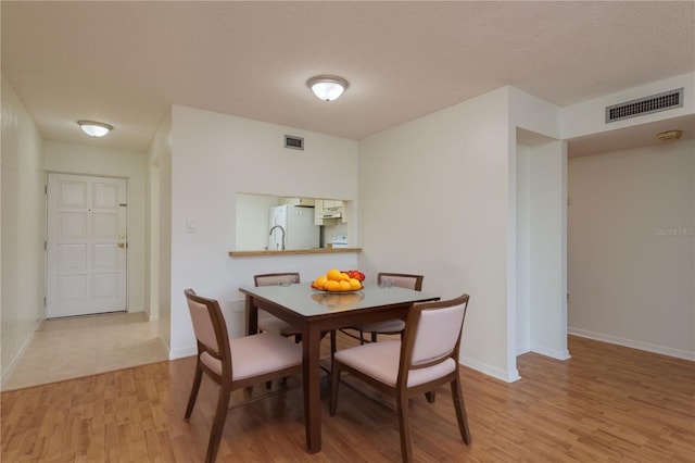 2650 Countryside Blvd Unit C204, Clearwater, FL 33761 - dining area featuring wood finished floors and a textured ceiling
