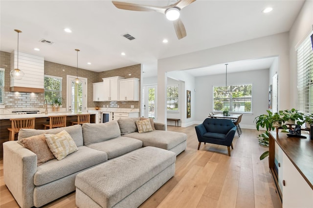 238 7th Ave S, Safety Harbor, FL 34695 - living room with light wood-type flooring, plenty of natural light, recessed lighting, ceiling fan, and beverage cooler