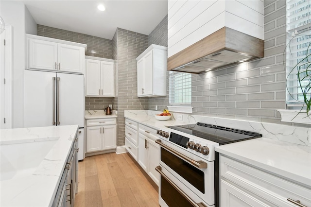 238 7th Ave S, Safety Harbor, FL 34695 - kitchen featuring double oven range, custom exhaust hood, light wood-style flooring, white cabinets, and recessed lighting