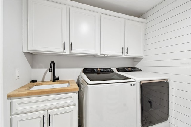 238 7th Ave S, Safety Harbor, FL 34695 - washroom featuring separate washer and dryer, cabinet space, and wooden walls