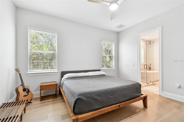 238 7th Ave S, Safety Harbor, FL 34695 - bedroom with light wood-type flooring, connected bathroom, and a ceiling fan