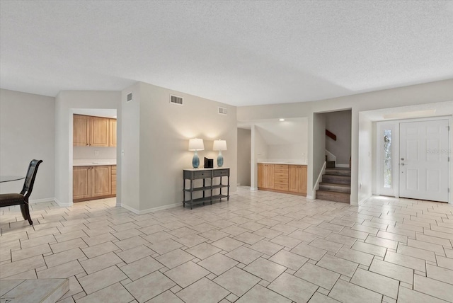 4777 Duhme Rd Unit 1D, Saint Petersburg, FL 33708 - unfurnished living room with stairway, a textured ceiling, and light tile patterned floors