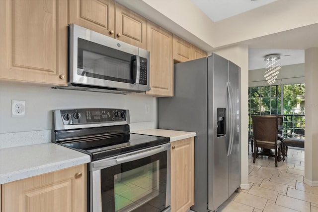 4777 Duhme Rd Unit 1D, Saint Petersburg, FL 33708 - kitchen with stainless steel appliances, light brown cabinets, light tile patterned floors, and light stone counters