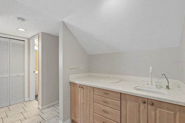 4777 Duhme Rd Unit 1D, Saint Petersburg, FL 33708 - bathroom featuring a textured ceiling, lofted ceiling, a closet, and vanity