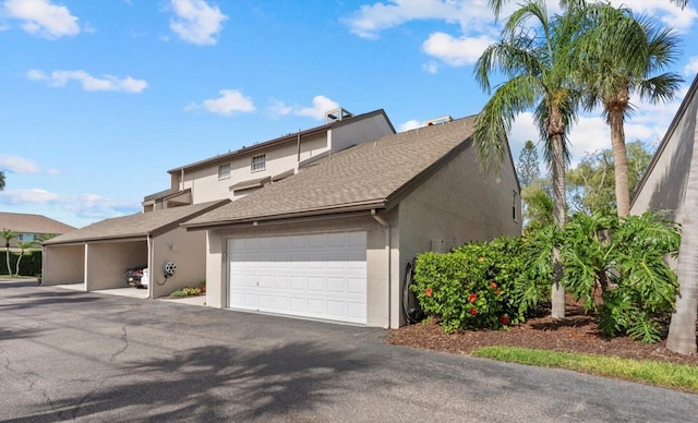 4777 Duhme Rd Unit 1D, Saint Petersburg, FL 33708 - view of front of property featuring stucco siding, roof with shingles, and a garage