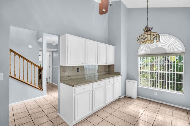 1715 Larabie Ct, Brandon, FL 33511 - kitchen featuring white cabinets, light tile patterned flooring, a high ceiling, backsplash, and pendant lighting