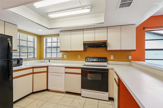 7470 Canterbury St, Spring Hill, FL 34606 - kitchen featuring black appliances, under cabinet range hood, a tray ceiling, and light countertops