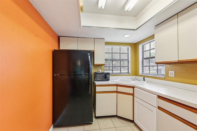 7470 Canterbury St, Spring Hill, FL 34606 - kitchen featuring black appliances, white cabinets, light countertops, and light tile patterned floors