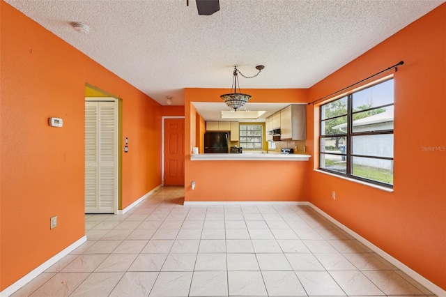 7470 Canterbury St, Spring Hill, FL 34606 - kitchen with fridge, a textured ceiling, light countertops, and decorative light fixtures