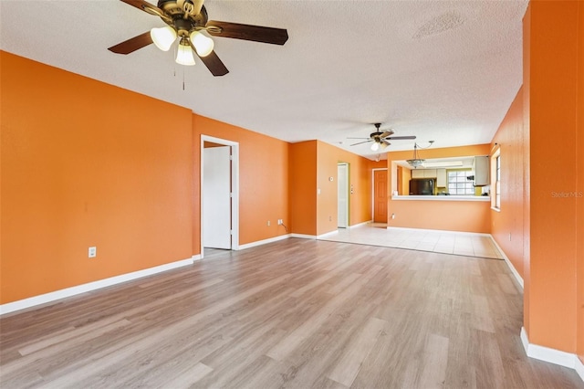 7470 Canterbury St, Spring Hill, FL 34606 - unfurnished living room featuring a ceiling fan, light wood-type flooring, and a textured ceiling