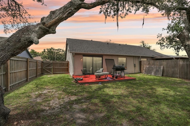 7470 Canterbury St, Spring Hill, FL 34606 - back of house at dusk with a fenced backyard, stucco siding, a wooden deck, and roof with shingles
