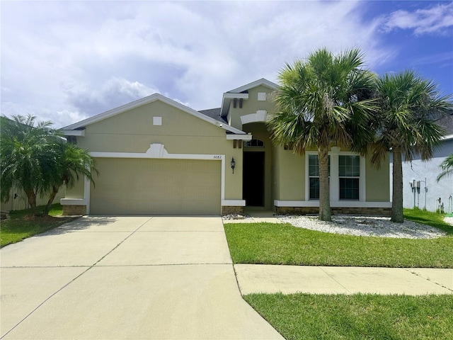 5082 Inshore Landings Dr, Apollo Beach, FL 33572 - view of front of house featuring a garage, stucco siding, concrete driveway, and a front yard