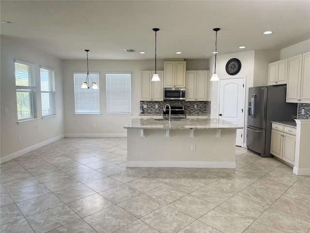 5082 Inshore Landings Dr, Apollo Beach, FL 33572 - kitchen featuring stainless steel appliances, decorative backsplash, recessed lighting, light stone counters, and light tile patterned flooring